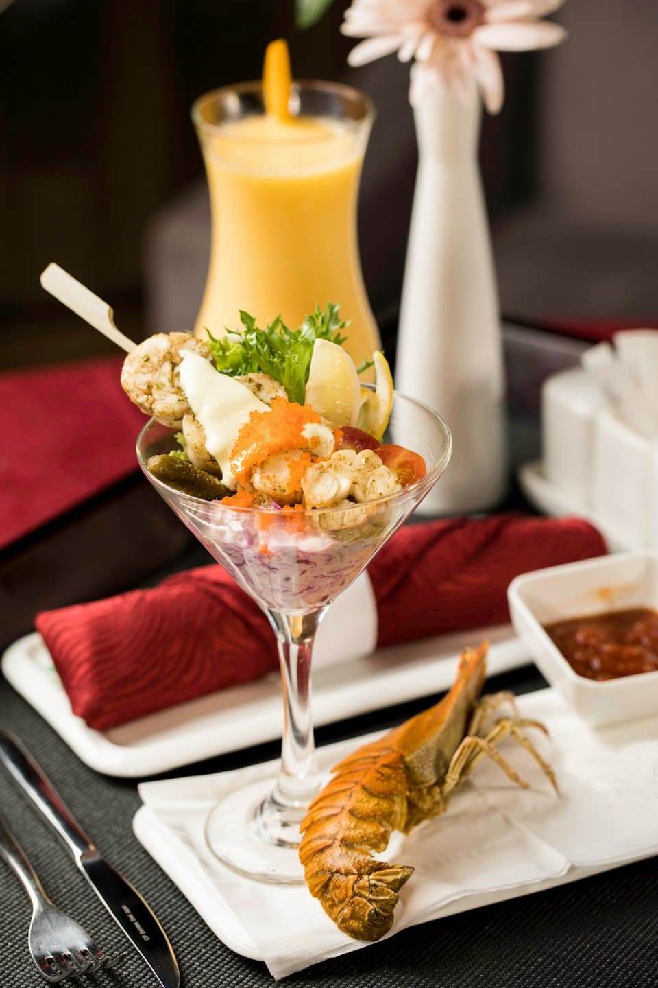 Cóctel gourmet de mariscos servido en copa de martini con langosta.