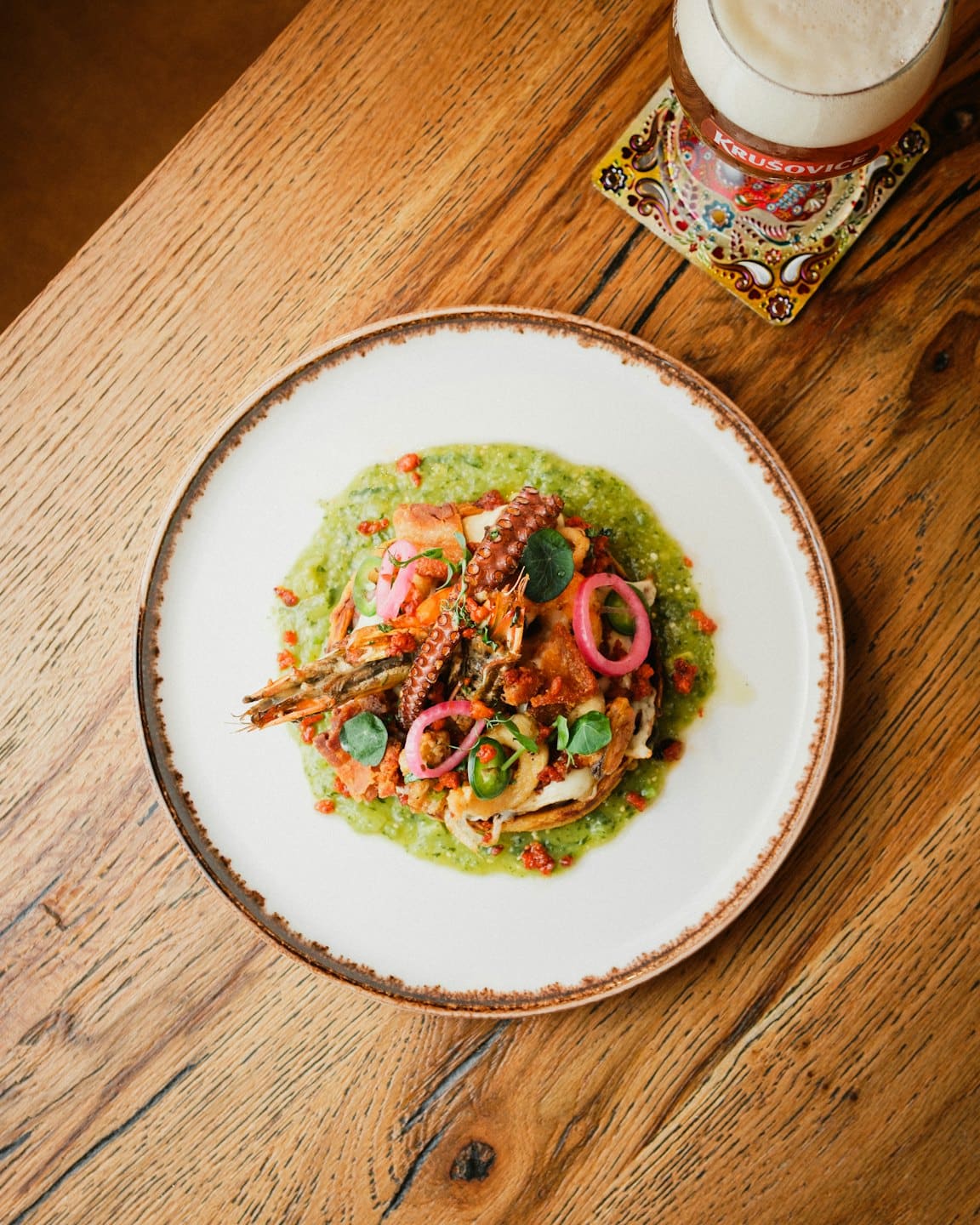 Plato de mariscos con pulpo y camarones sobre una mesa de madera.